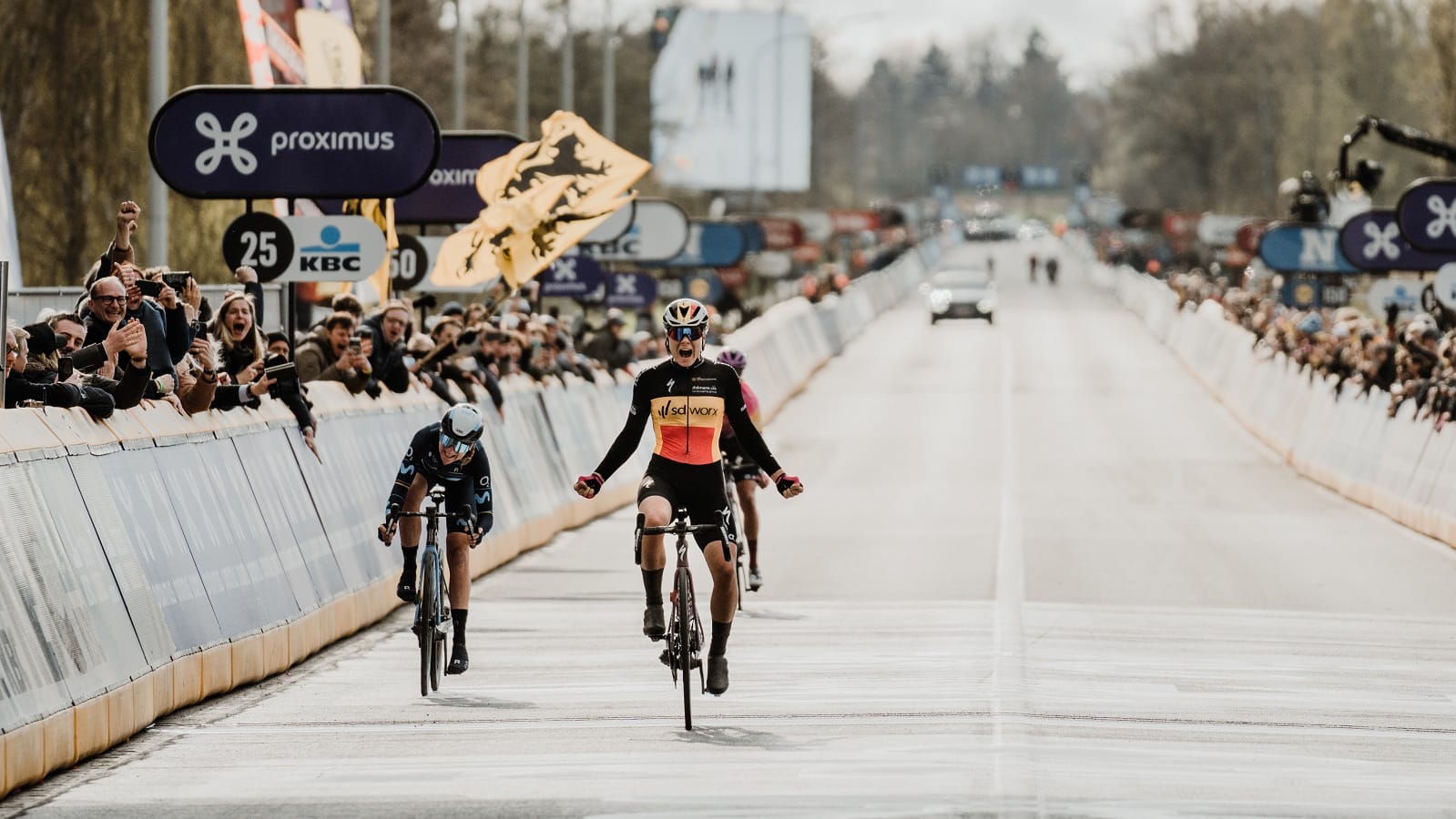 Spectators cheer on riders on the final straight of the Tour of Flanders